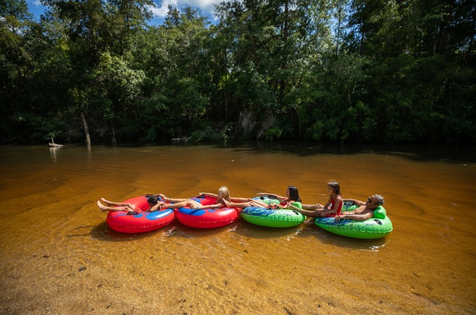 family tubing down the sandy bottom blackwater river