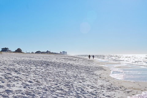 Strolling along an uncrowded beach and watching the whitecaps