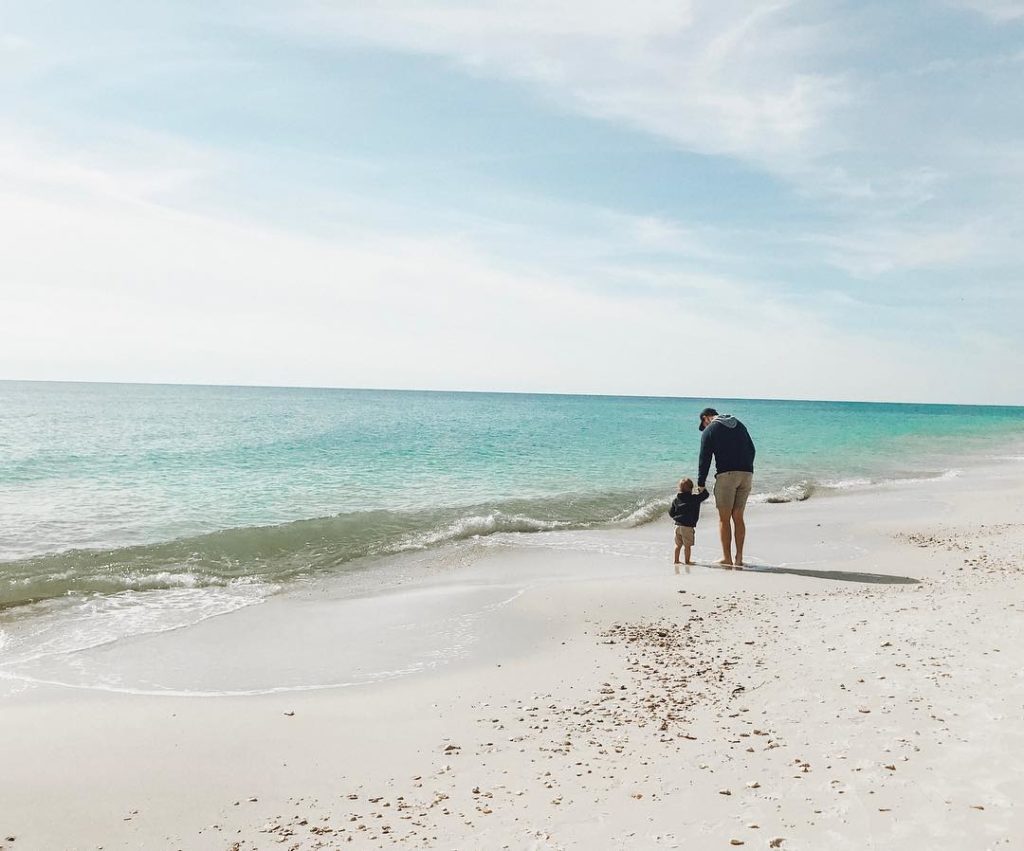 Dad and baby walking on sand