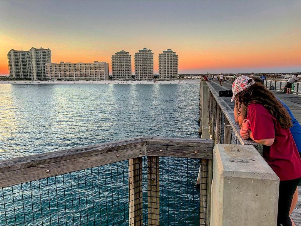 Kids looking at water from Navarre Pier with summer sunset