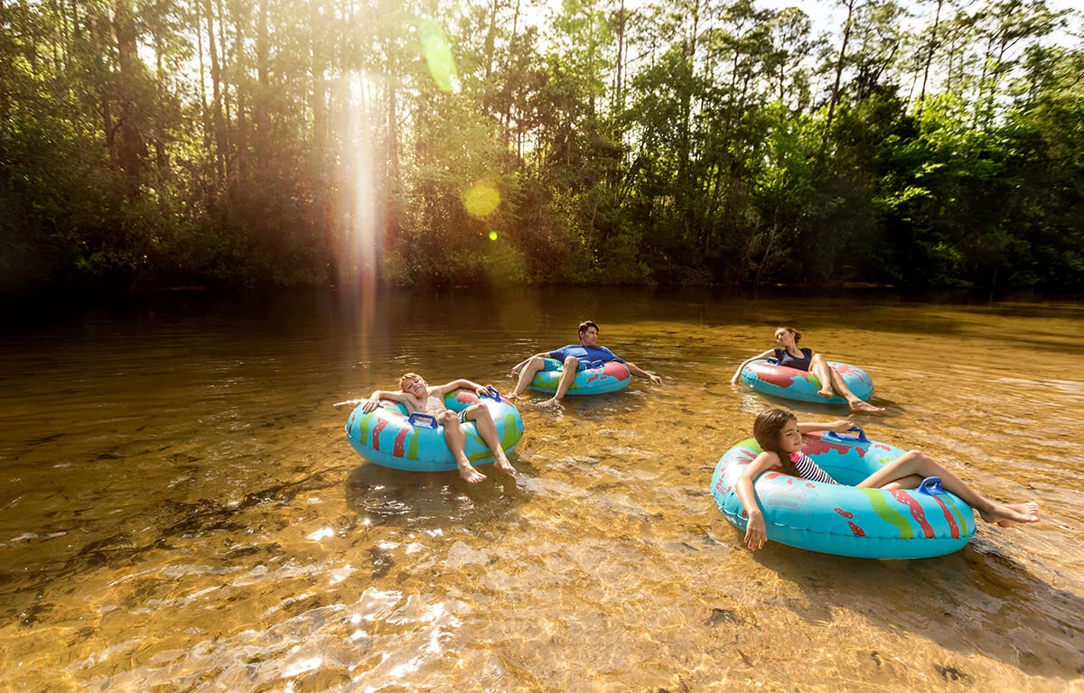 a family floating in the river on tubes