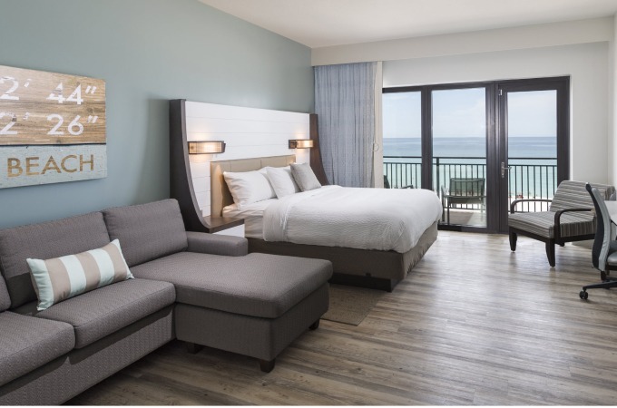 queen bed hotel room with beachfront view and balcony