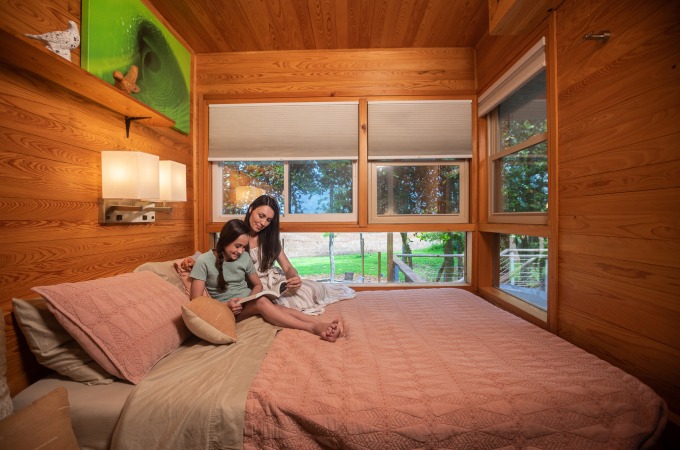 mother reads to daughter on bed overlooking cotton fields