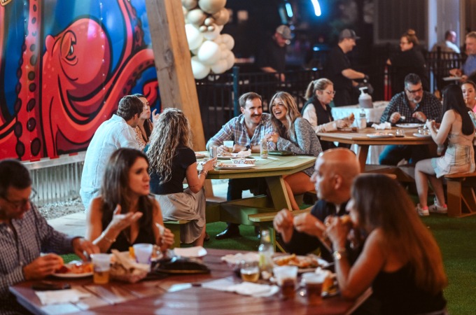 families eating at circular picnic tables outside